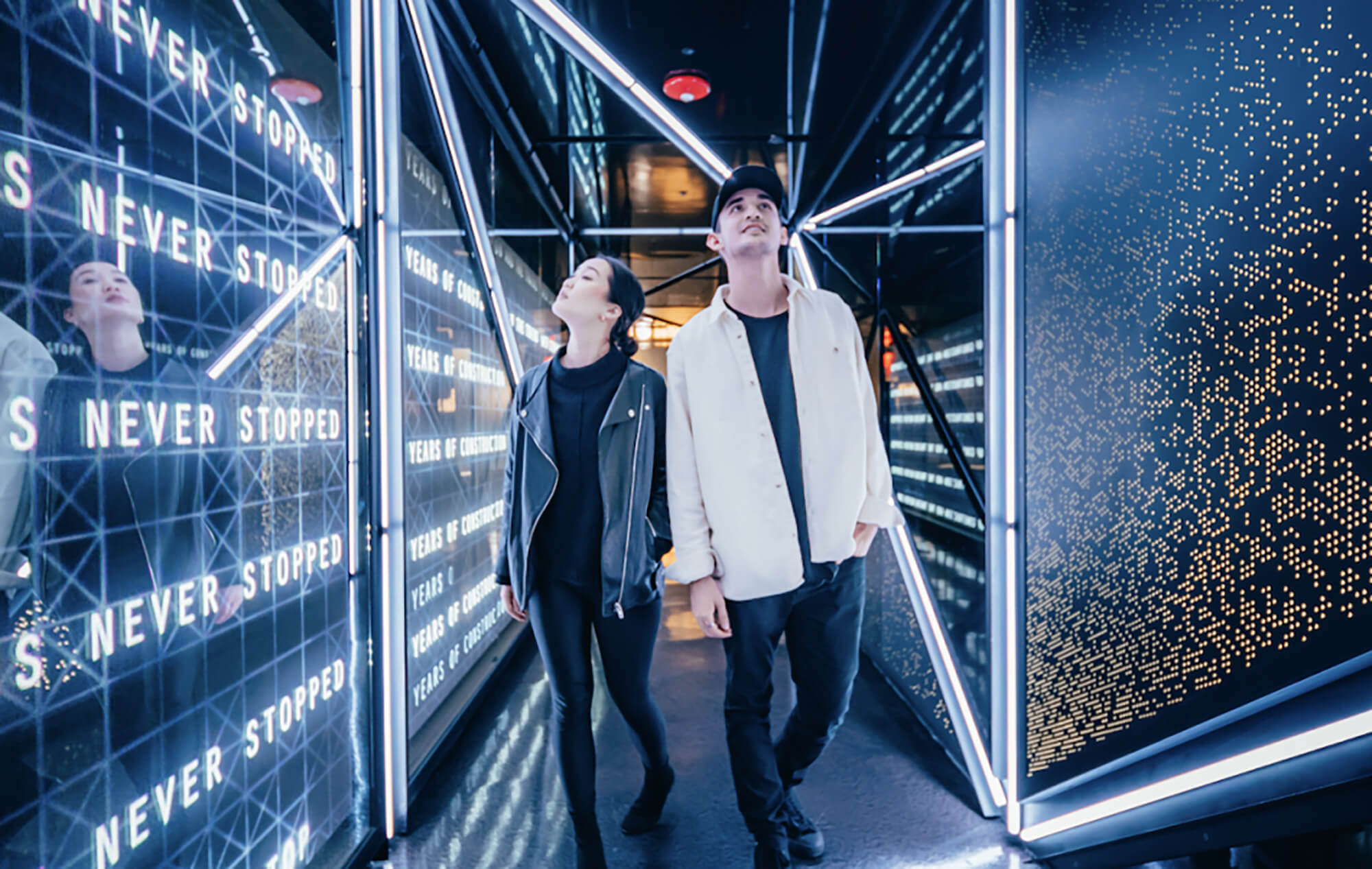 A couple walking hand in hand through an exhibit at Hudson Yards