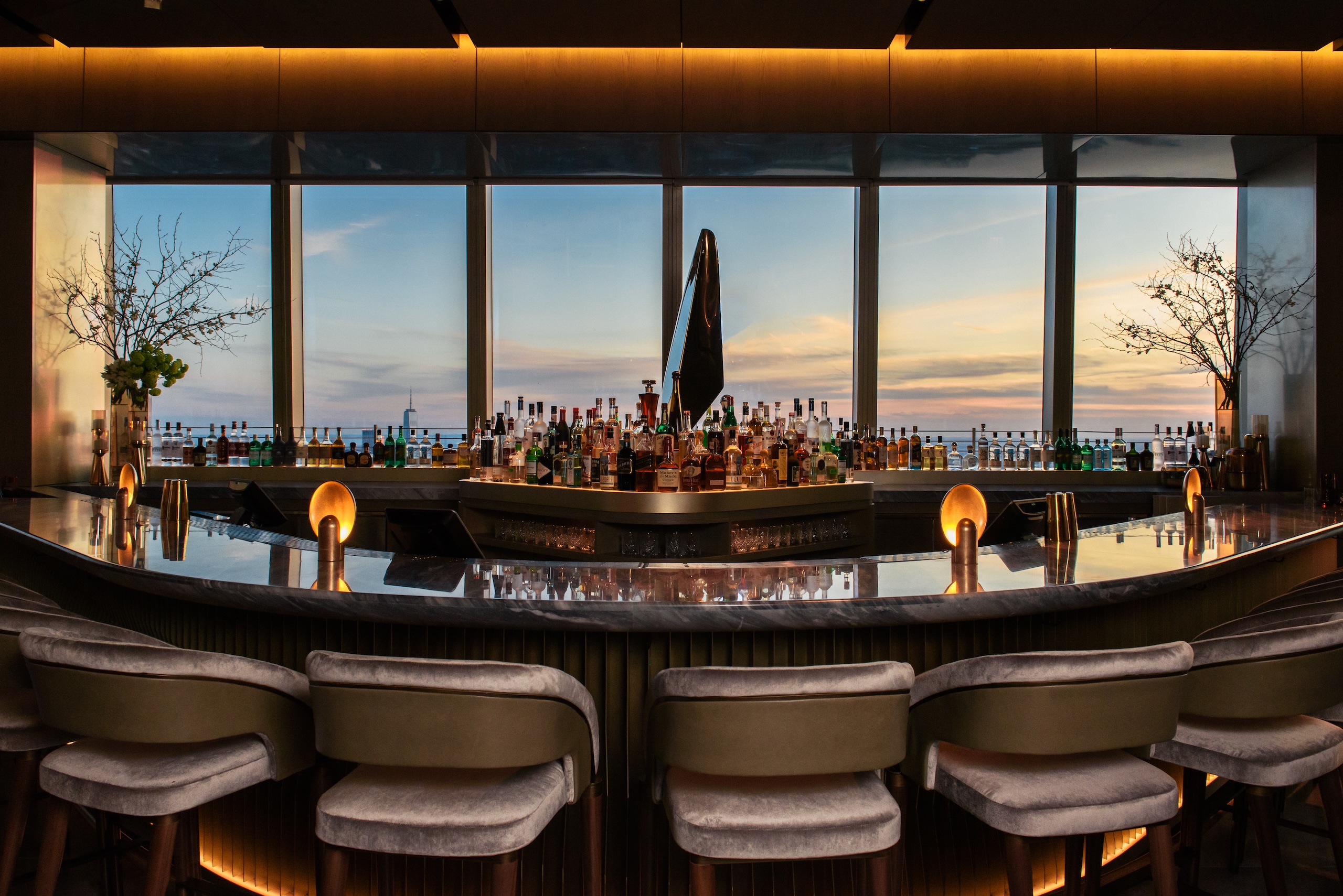 Peak Bar with large windows overlooking the sunset at The Edge